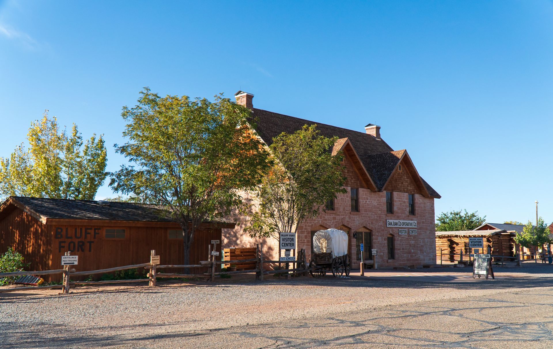 A large brick building with a covered wagon parked in front of it.