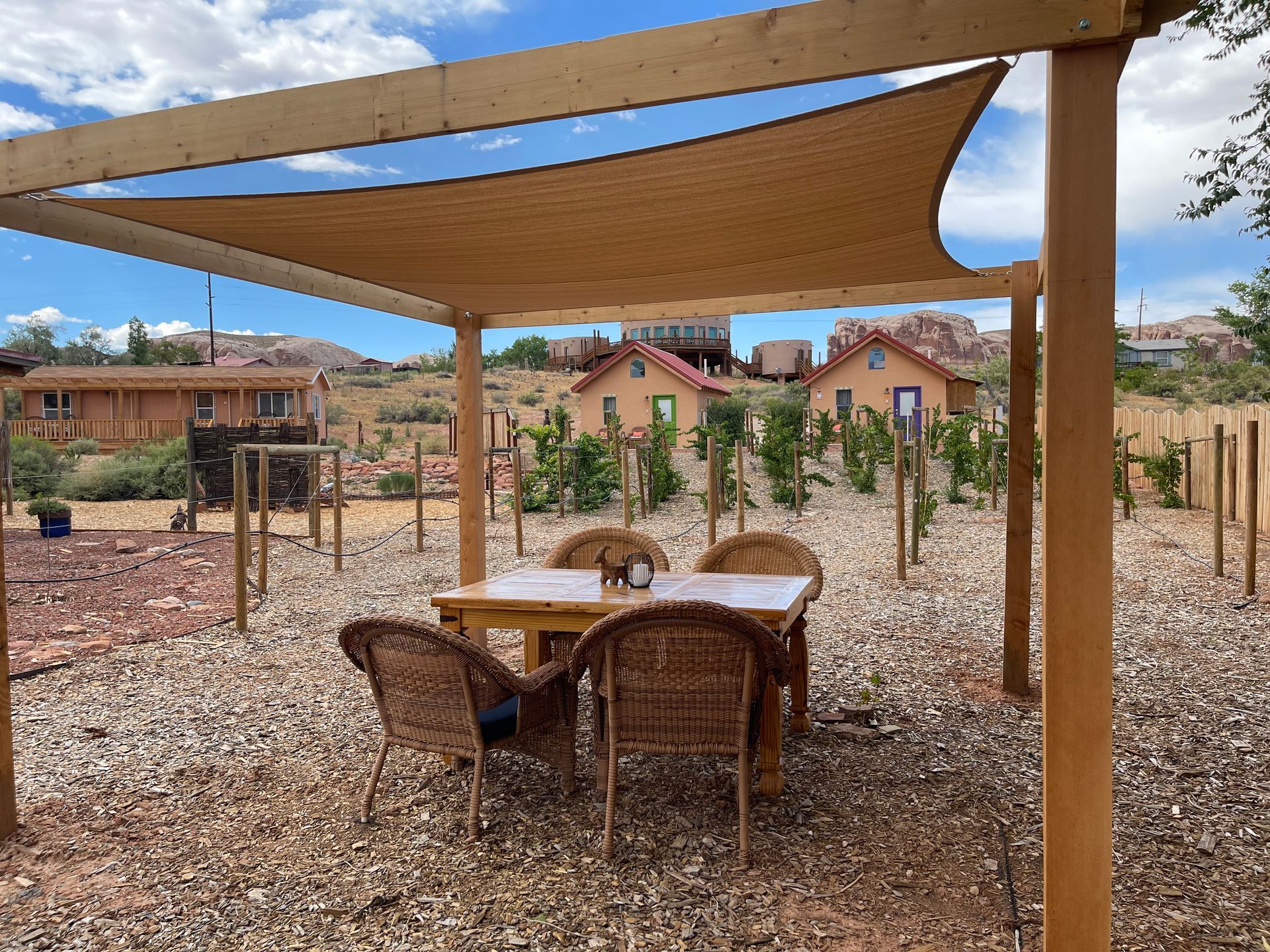 A table and chairs under a canopy in the dirt