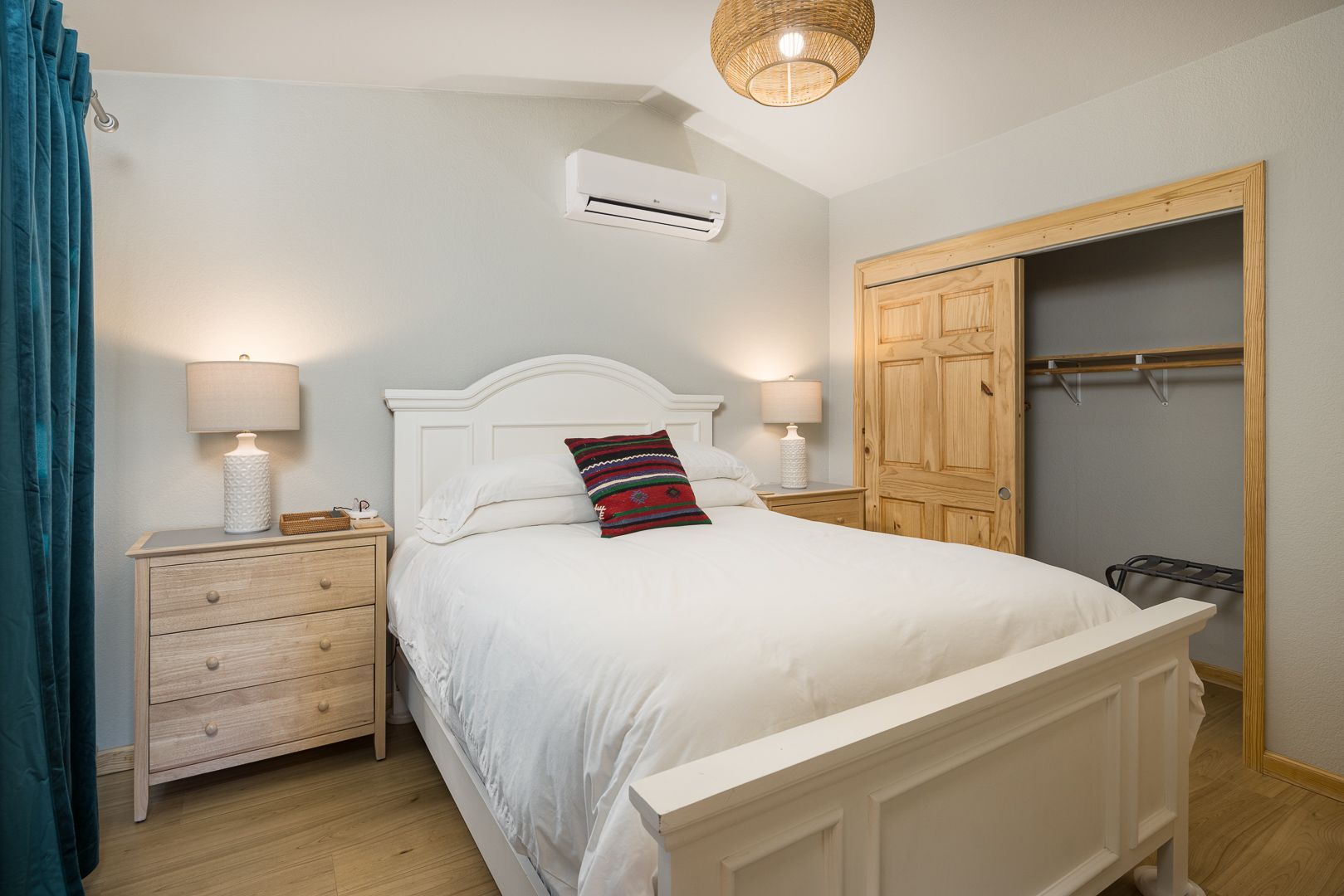 A bedroom with a bed , nightstand , dresser and closet.