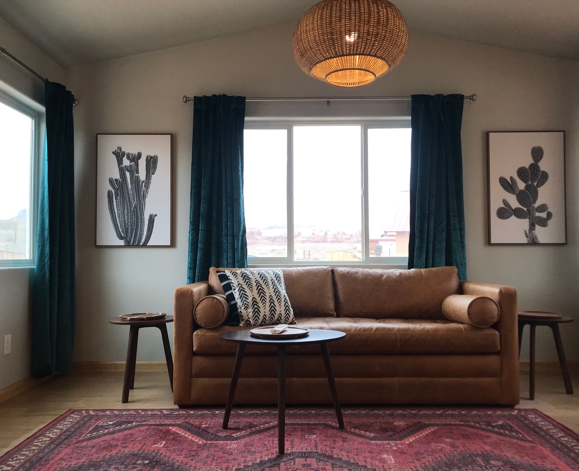 A living room with a brown leather couch and a rug