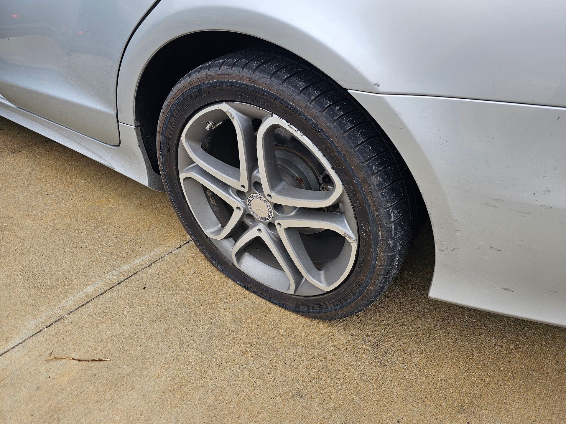 Silver car tire on paved surface. | Hometown Automotive