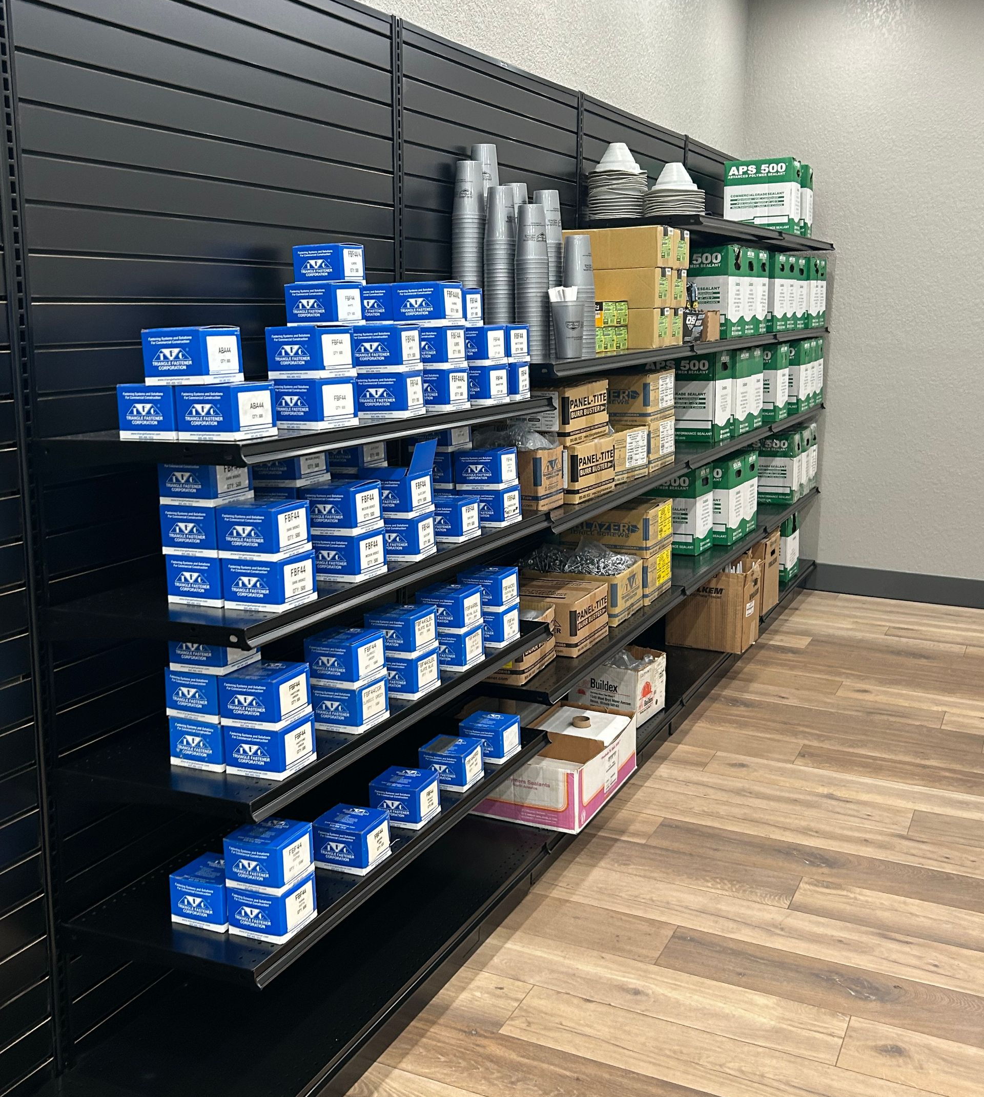 Black shelves filled with various products: blue boxes, metal canisters, and green containers.