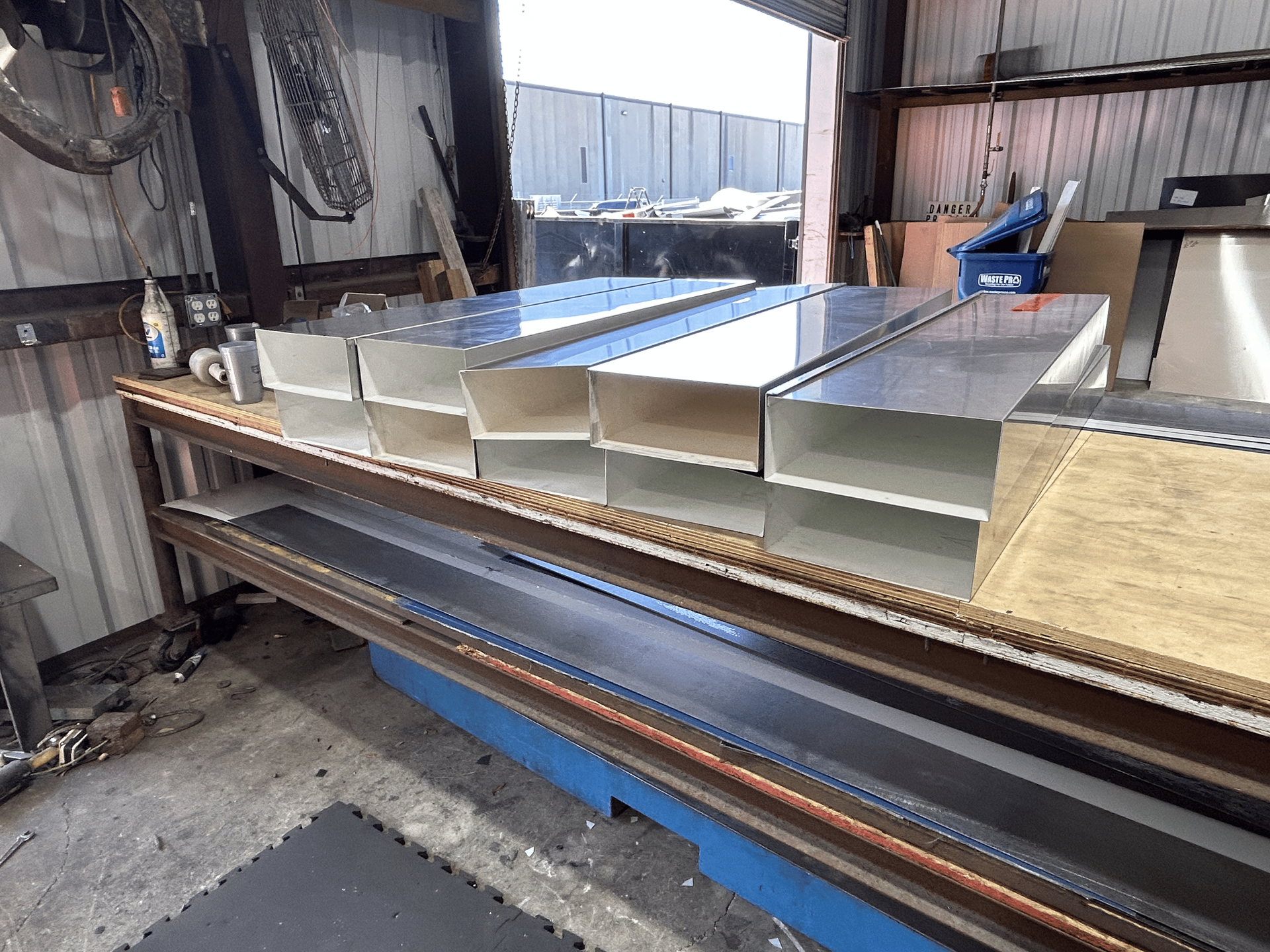 Metal fabrication workshop: Aluminum boxes sit on a workbench.