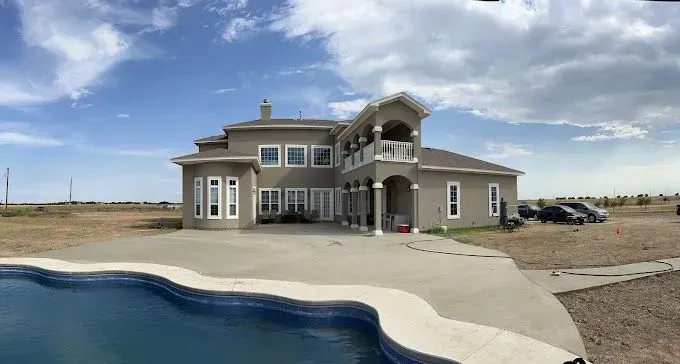 A large house with a swimming pool in front of it.