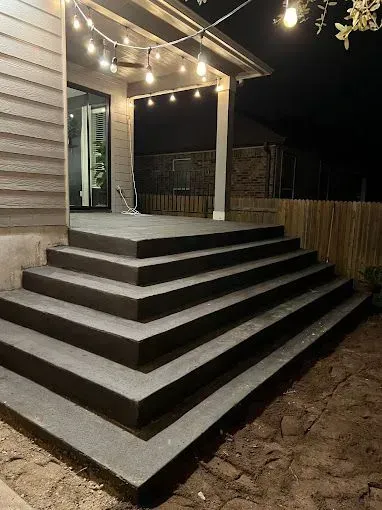 A set of stairs leading up to a porch at night.
