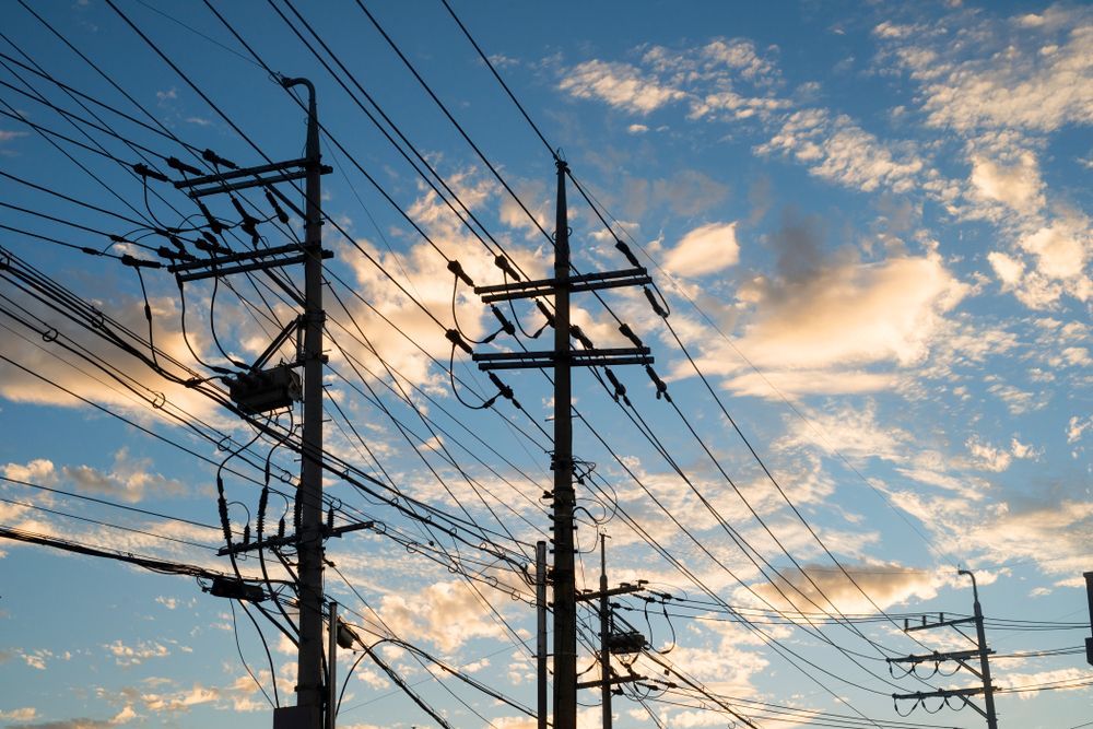 Power Lines and Poles Against a Blue Sky With Fluffy Clouds — Australian Mobile Welding Pty Ltd in Atherton, QLD