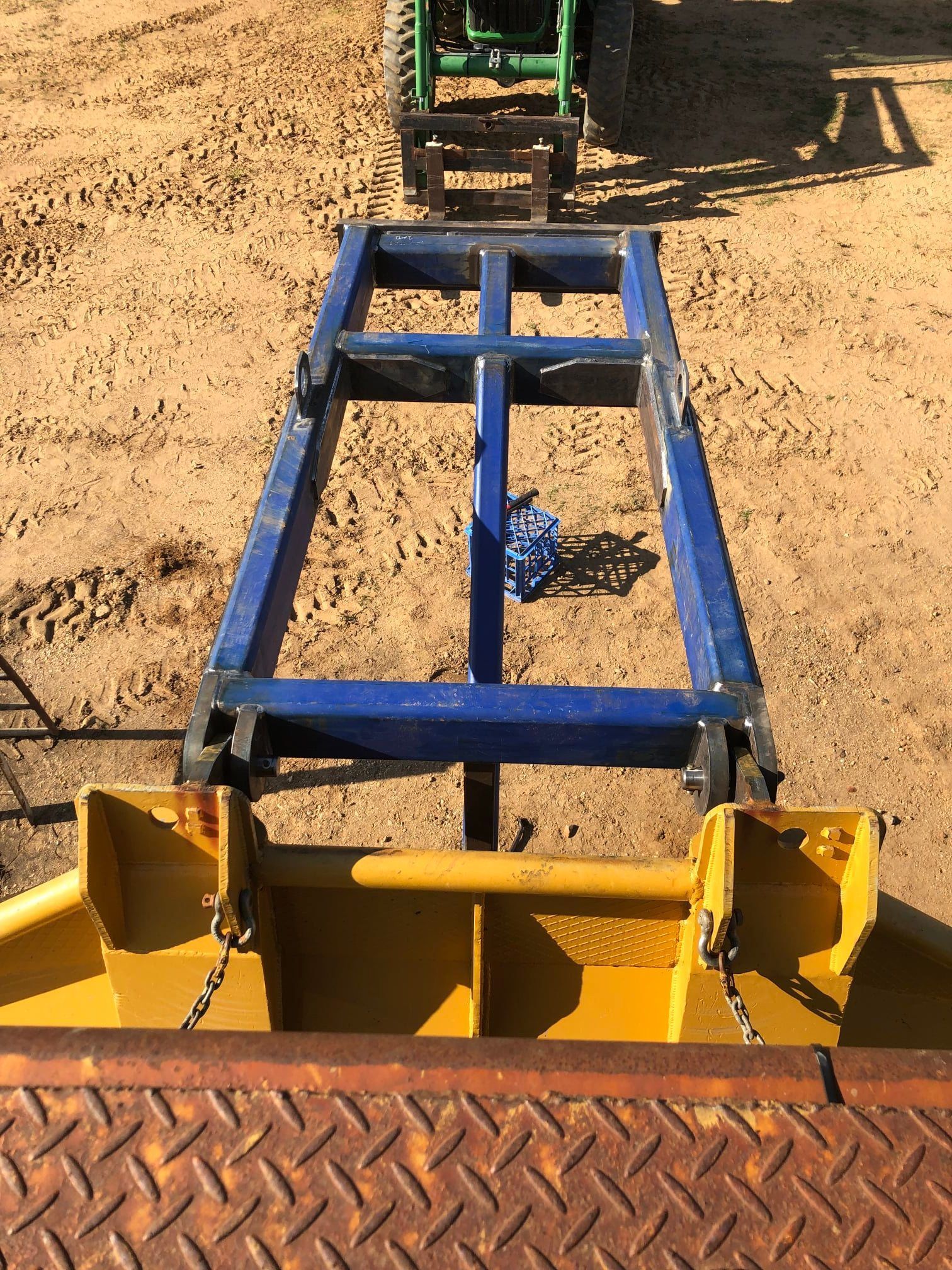 A Blue and Yellow Metal Implement Attached to a Green Tractor — Australian Mobile Welding Pty Ltd in Georgetown, QLD