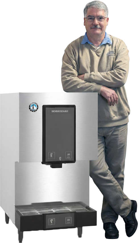 Man leans against an ice machine. He is wearing glasses, a sweater, and khaki pants. The machine is stainless steel.