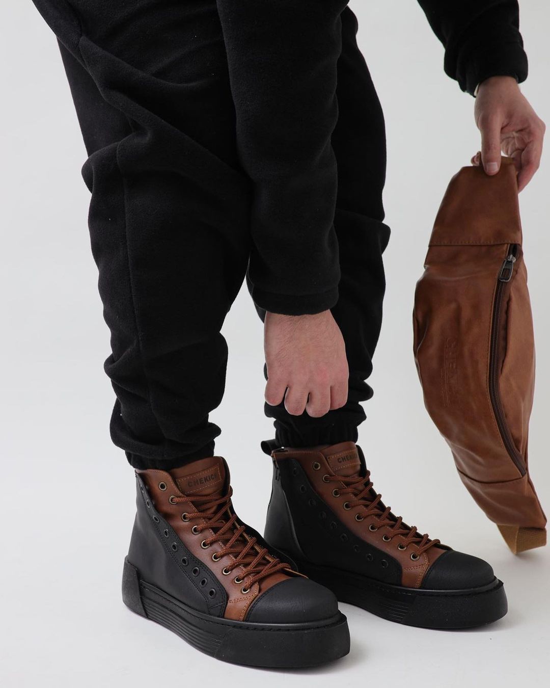 Una persona que lleva un par de zapatos marrones y negros.