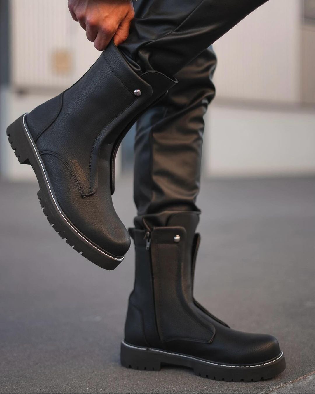 Una persona se pone un par de botas negras.
