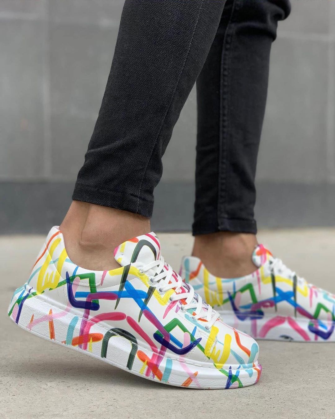 Una persona lleva un par de zapatillas de colores.