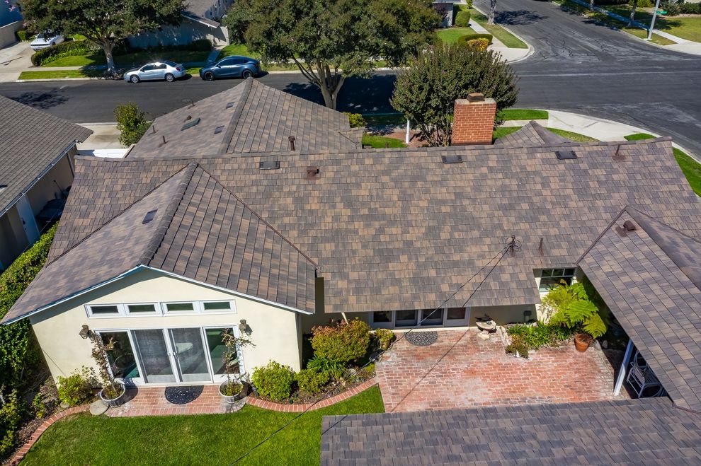 Ladder leaning against a house with gray siding. Construction is visible near the roofline.