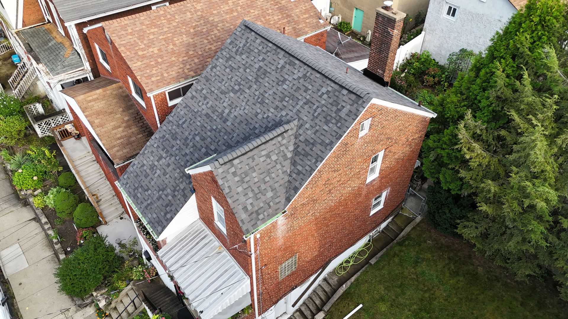 Gray asphalt shingle roof, with a pattern of overlapping squares, covering a house.