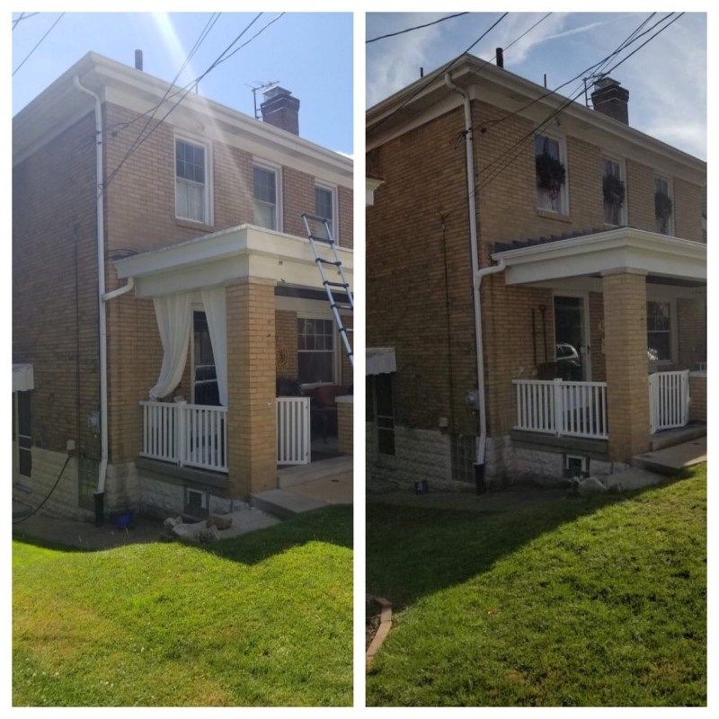 Two-story brick house, before and after exterior cleaning. White trim, porch, and gutters. Green lawn, bright sunlight.