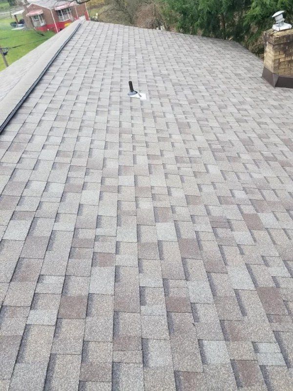 Roof covered with gray and brown asphalt shingles.