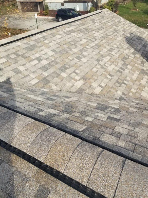 Asphalt shingle roof with varied gray and tan tones; black trim.