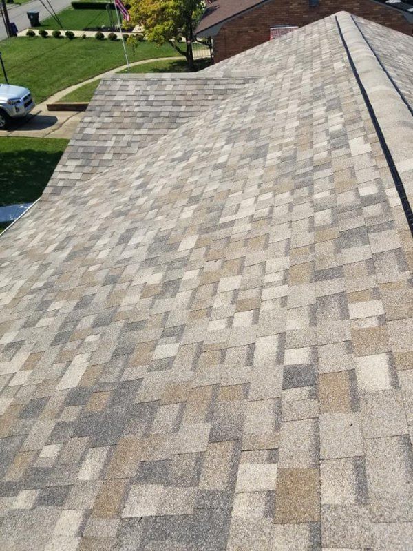Close-up of a multi-colored asphalt shingle roof on a house, angled view.