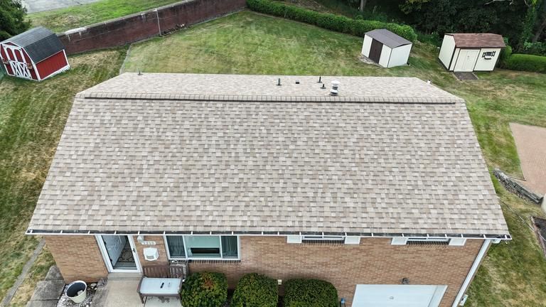 Angled roof with six rectangular skylights and brown shingles.