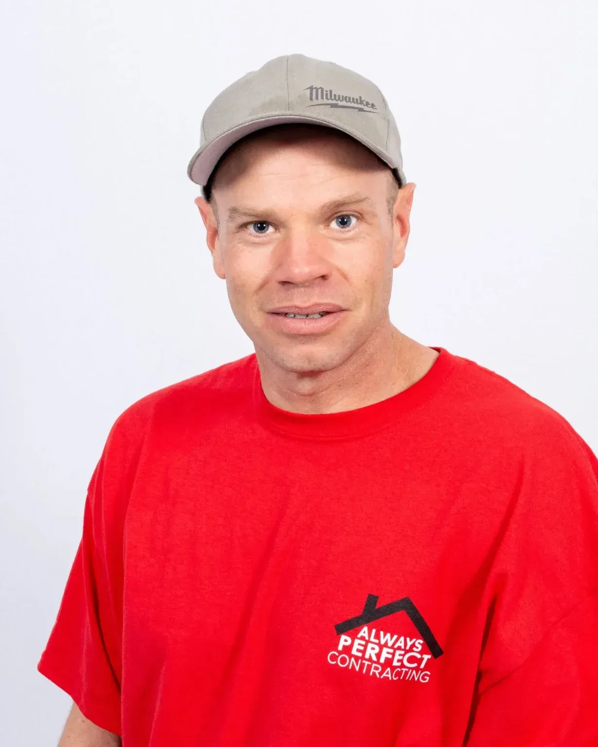 Man wearing a red t-shirt and baseball cap, smiling, with the Always Perfect Contracting logo.