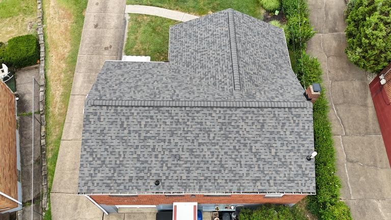 Bathroom with white tub, white brick-like tile walls, and dark blue mosaic tile floor.