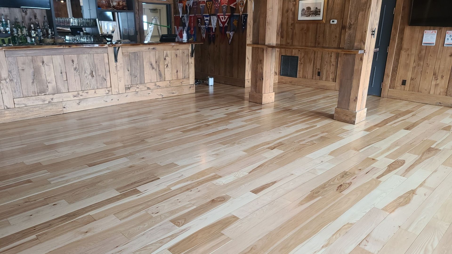 A large room with a wooden floor and a wooden bar.