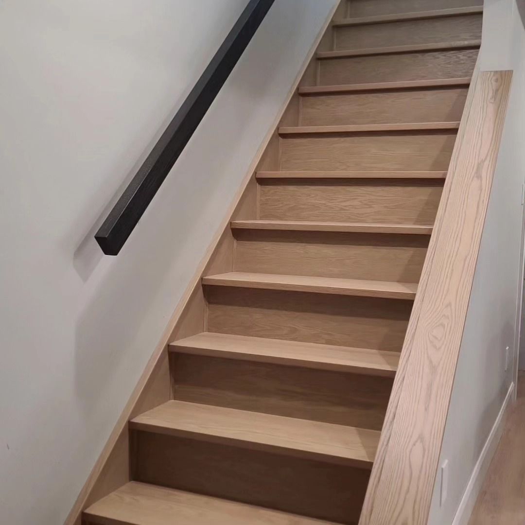 The stairs are made of wood and have a black railing.