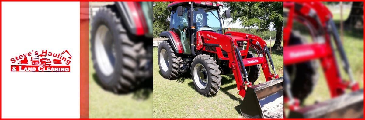 A red tractor is parked in a grassy field.