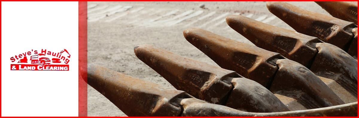 A close up of a excavator bucket with a logo in the corner.