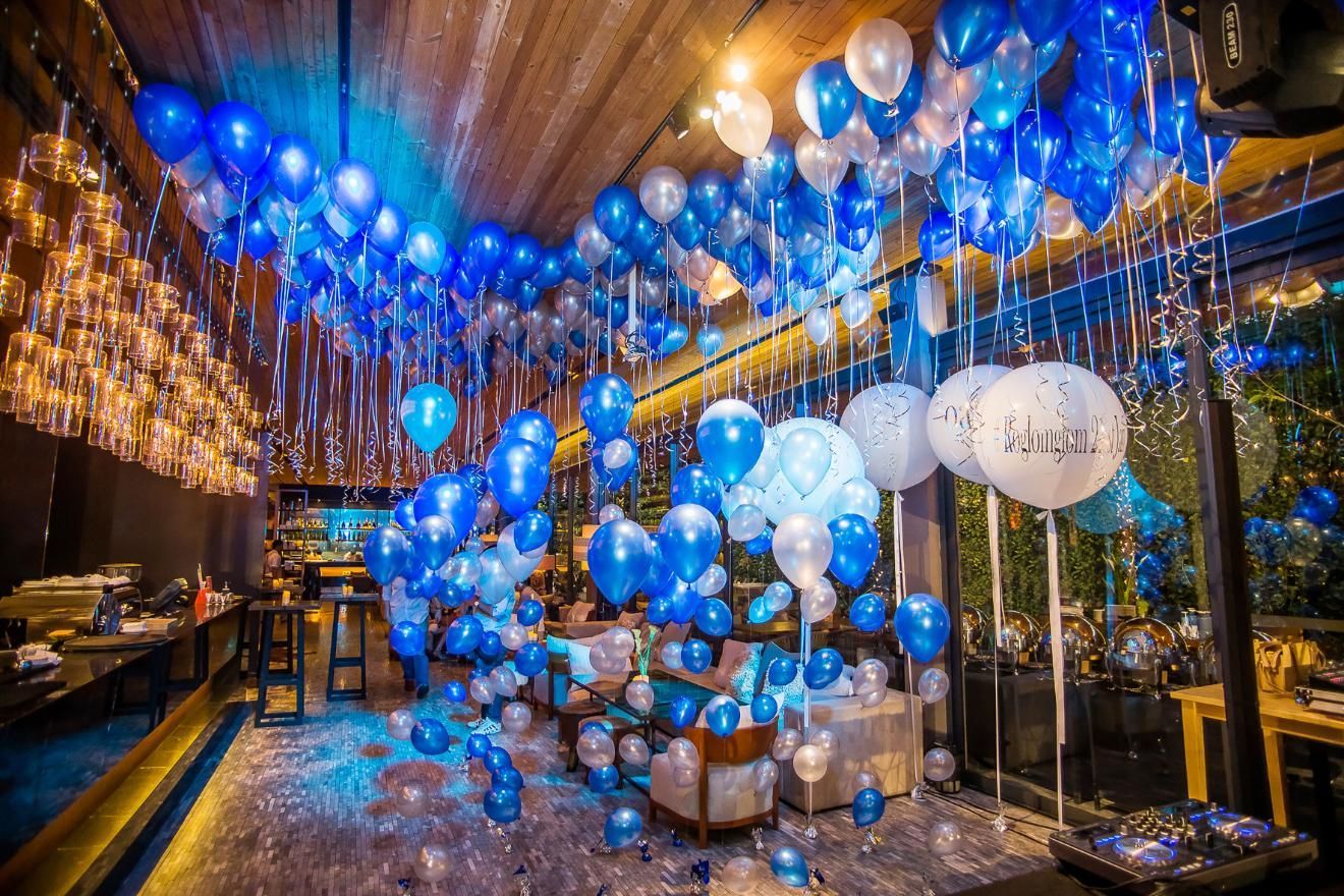 Blue and white balloon decorations filling a room, party or celebration setting.
