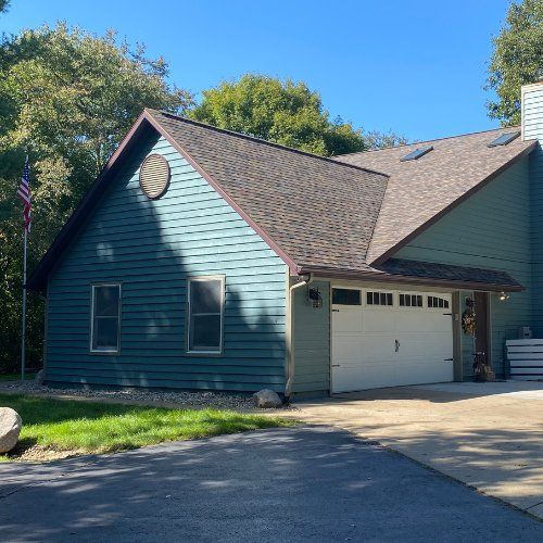 A house with a white garage door and a blue siding