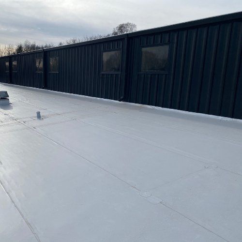 A white roof with a black building in the background.