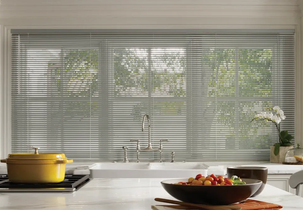 Modern kitchen with aluminum blinds hanging above a white kitchen sink.
