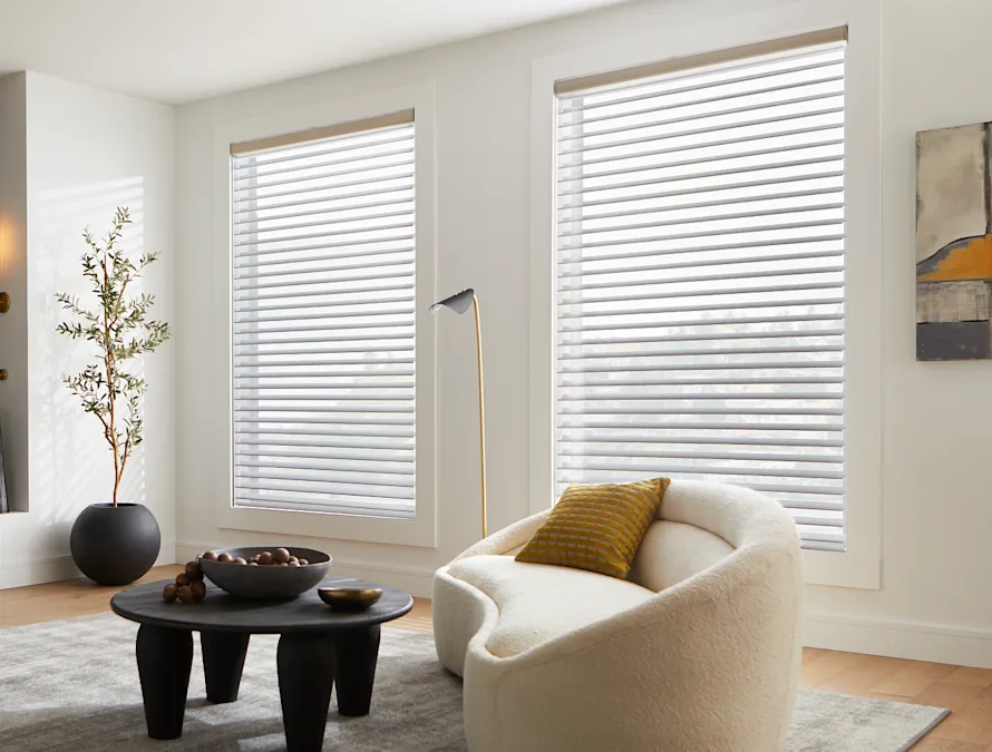Posh living room featuring accent chairs, coffee table, and custom sheer shades.