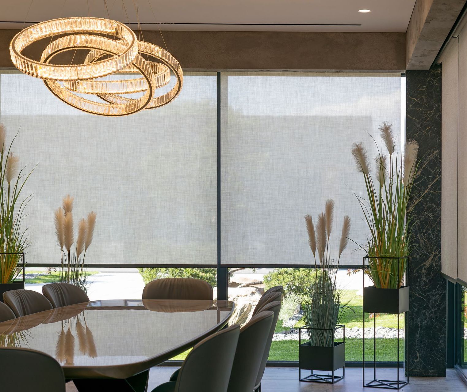 Dining room with long dining table and chair set with custom solar shades.
