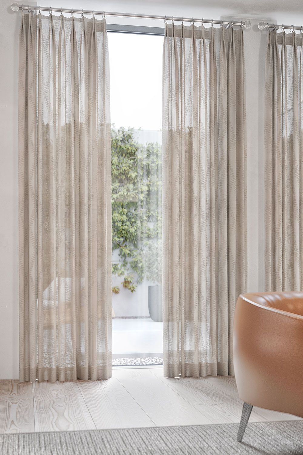 A couch with throw pillows in front of a window with cellular shades.
