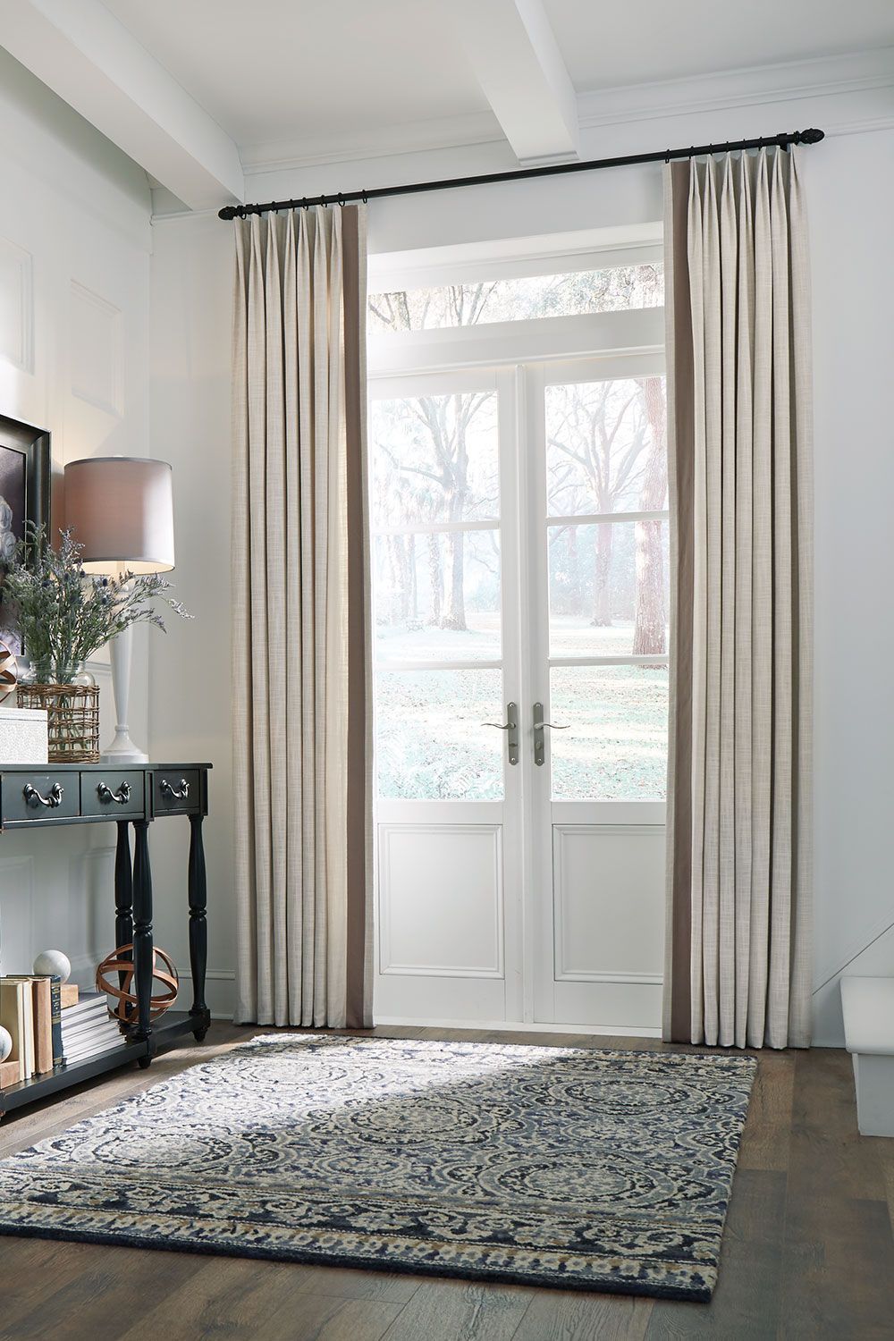 Contemporary bedroom with stylish throw pillows, end table, and custom Roman shades.