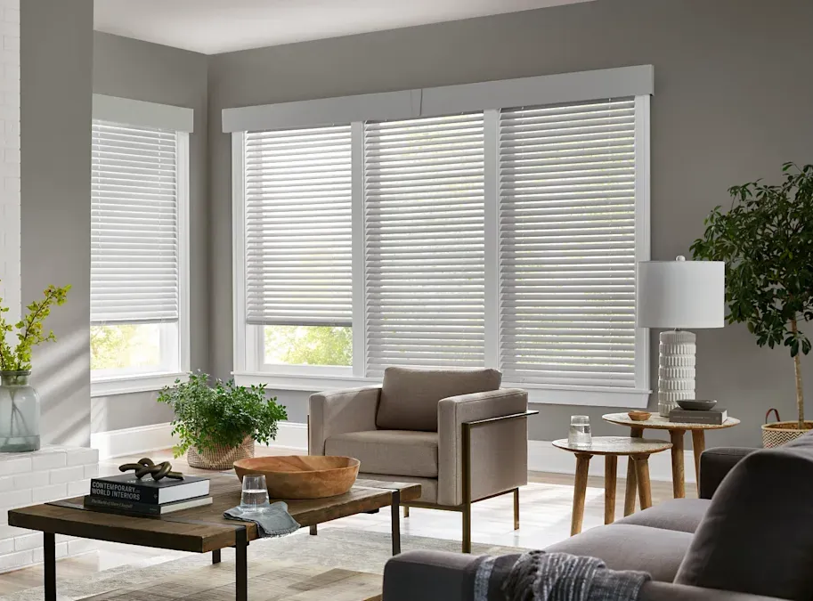 Posh living room with comfortable seating, coffee table, and multiple sets of custom blinds.