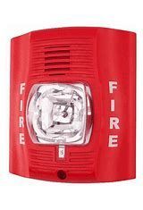A red fire alarm with a light on top of it.