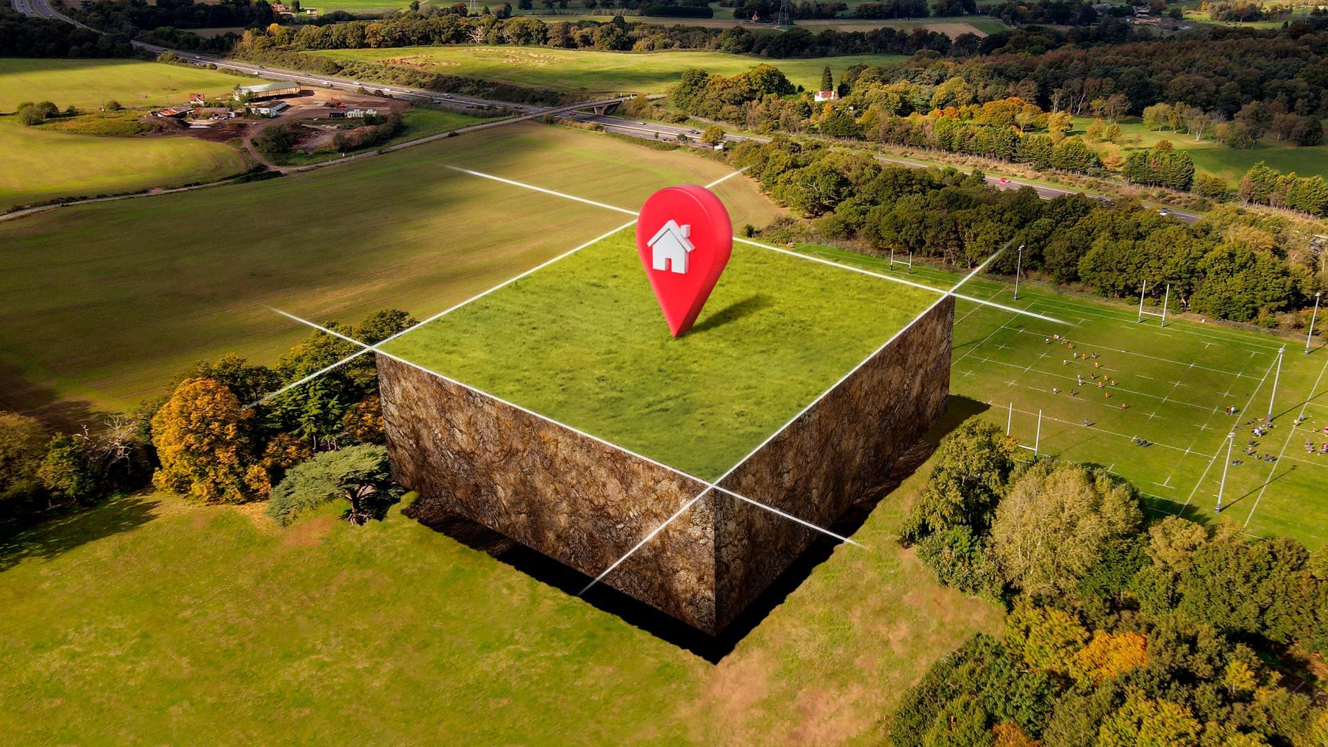 An aerial view of a piece of land with a house pin on top of it.