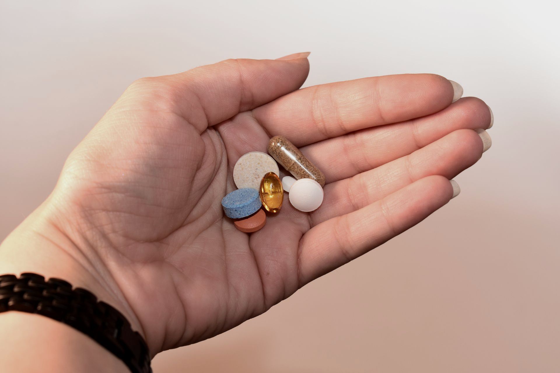 Hand Holding Medication Pill and Capsules