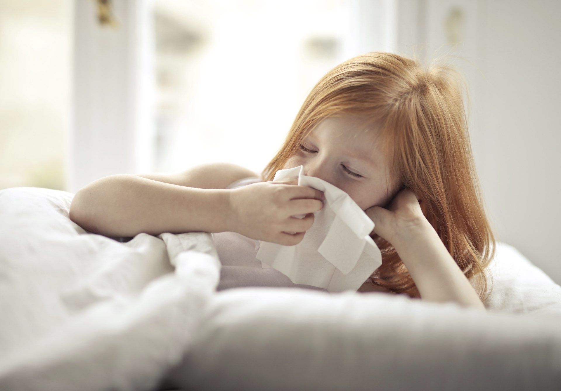 Sick Girl Wiping Her Nose with Tissue