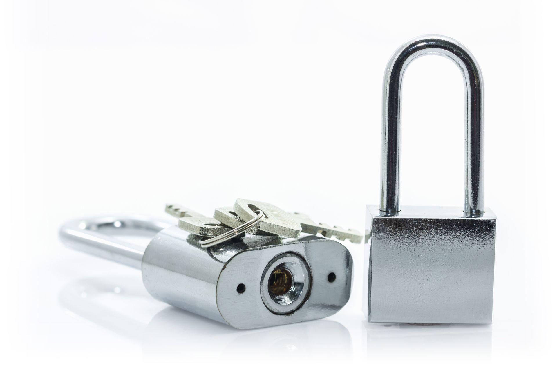 A close up of a padlock and keys on a white background.