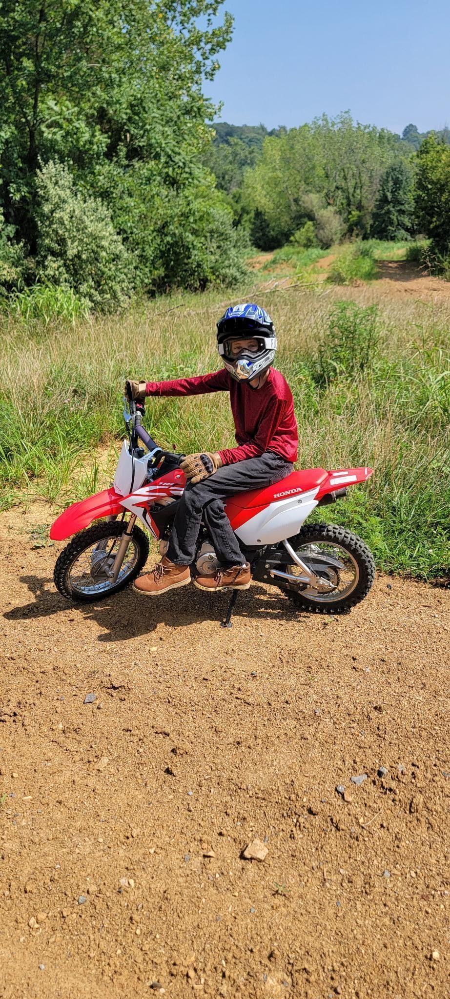 A person is riding a dirt bike on a dirt road