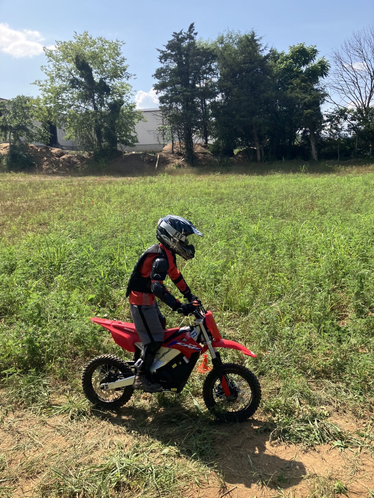 A young boy is riding a dirt bike in a field