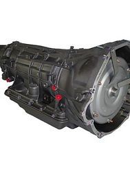 An automatic transmission, a large metal component with a silver torque converter visible on the right side.