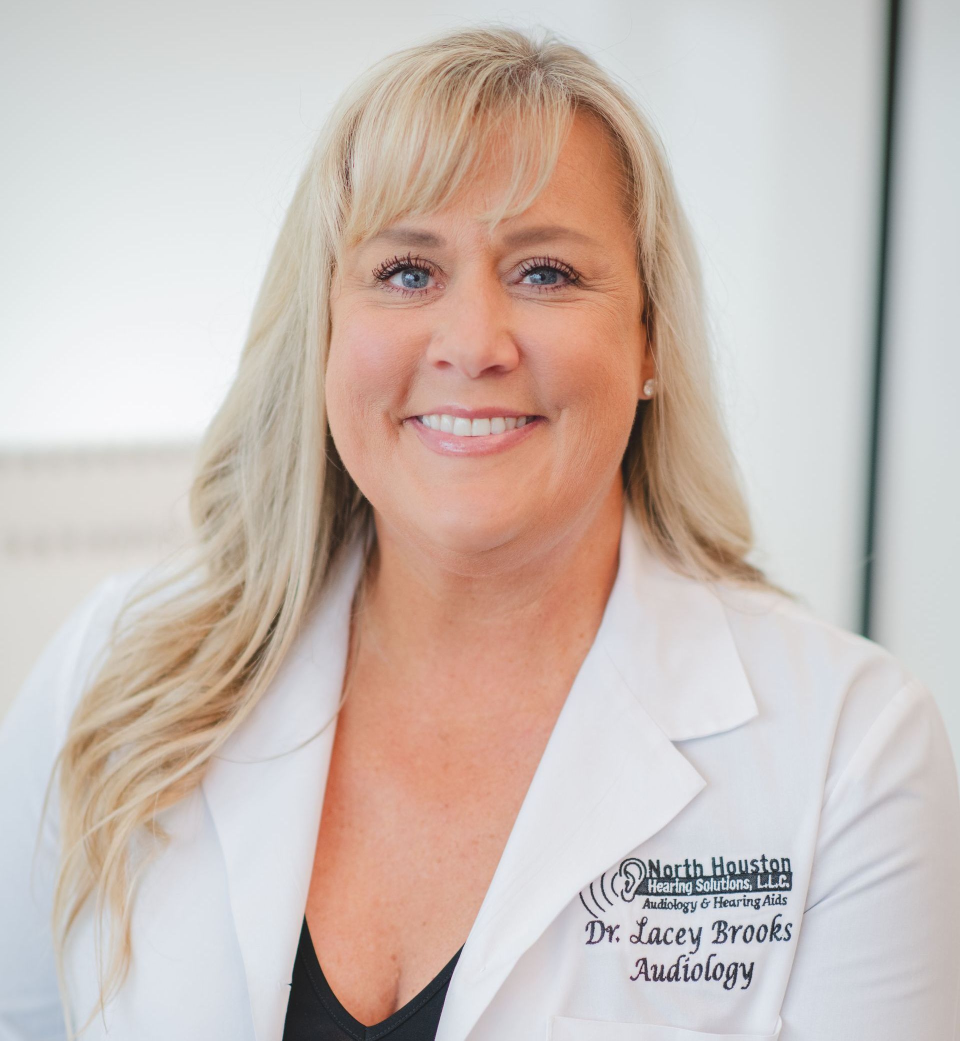 A woman wearing a white lab coat with the name dr. sarah brooks on it