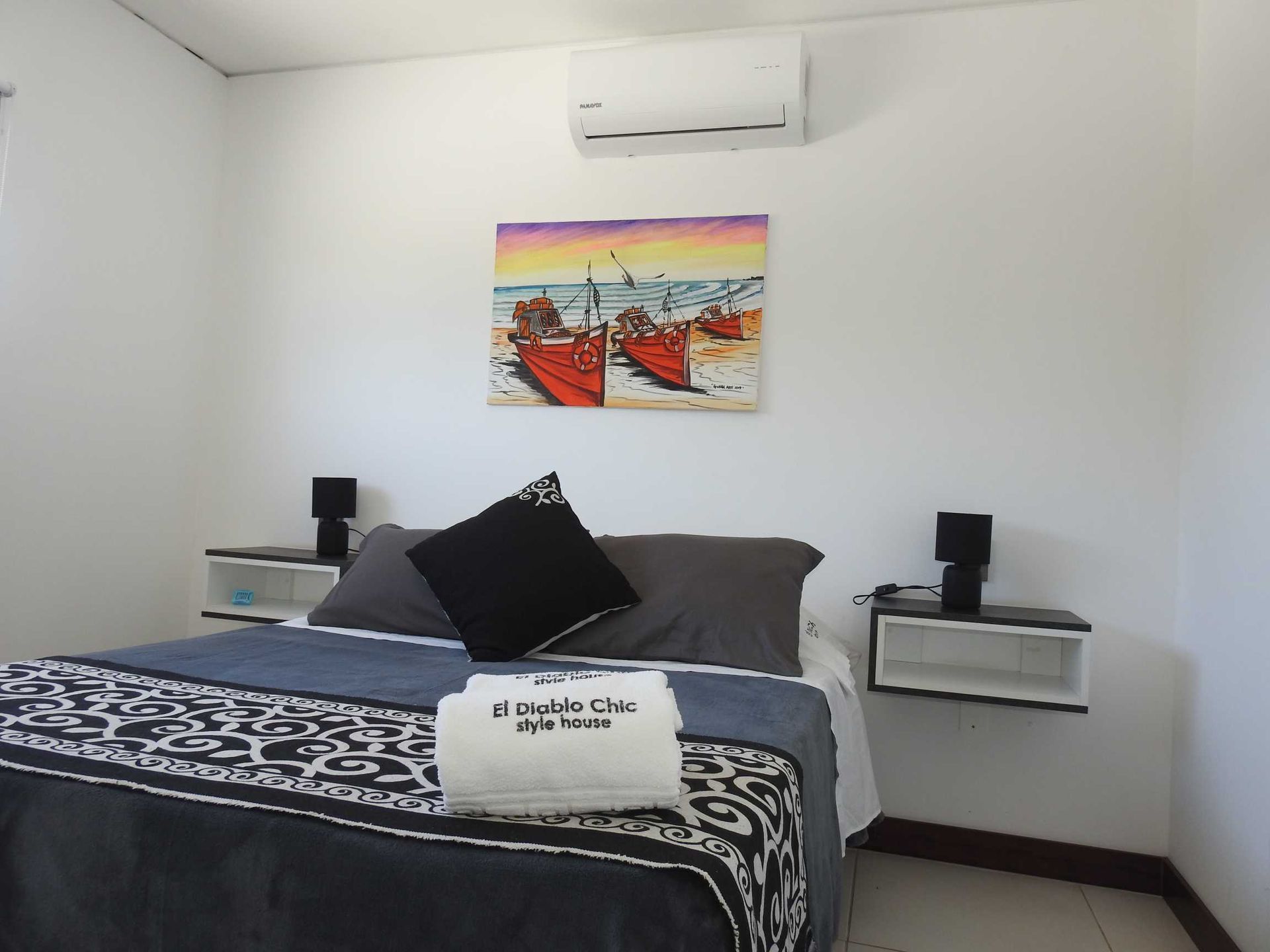 A bedroom with a bed and a painting on the wall