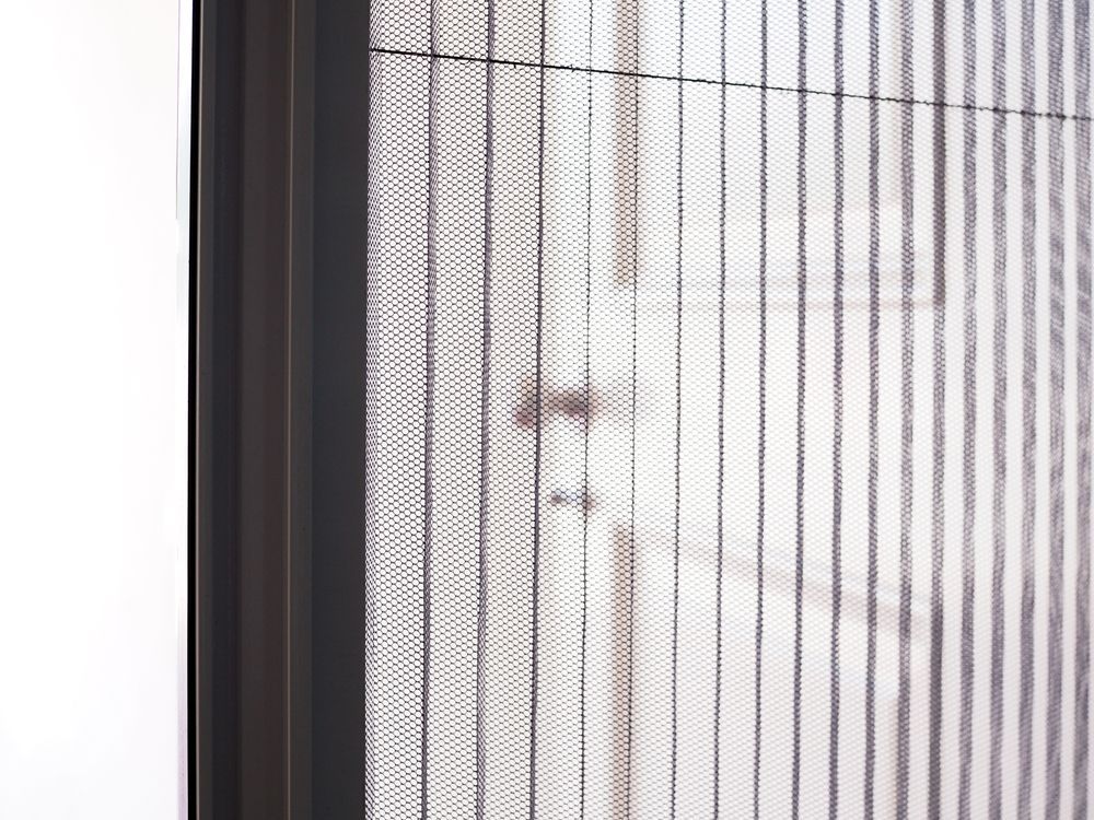 Dark Grey Retractable Insect Screen Covering a Doorway — Suburban Security Screens in Currumbin, QLD