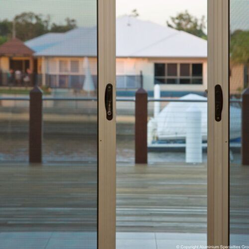 Sliding Glass Doors With Dark Frames Look Out — Suburban Security Screens in Currumbin, QLD