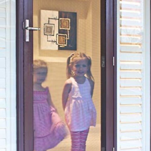 Young Child Standing in an Open Doorway — Suburban Security Screens in Currumbin, QLD